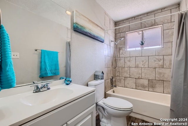 full bathroom with vanity, toilet, a textured ceiling, and shower / tub combo with curtain