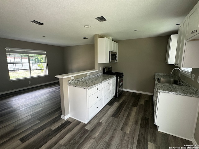 kitchen featuring sink, kitchen peninsula, stainless steel appliances, white cabinets, and dark wood-type flooring