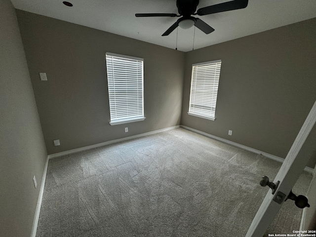 carpeted empty room featuring ceiling fan