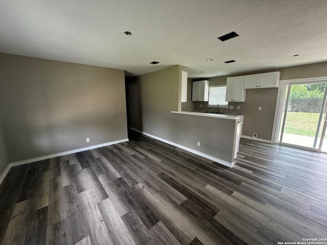 kitchen featuring white cabinetry, dark hardwood / wood-style flooring, and kitchen peninsula