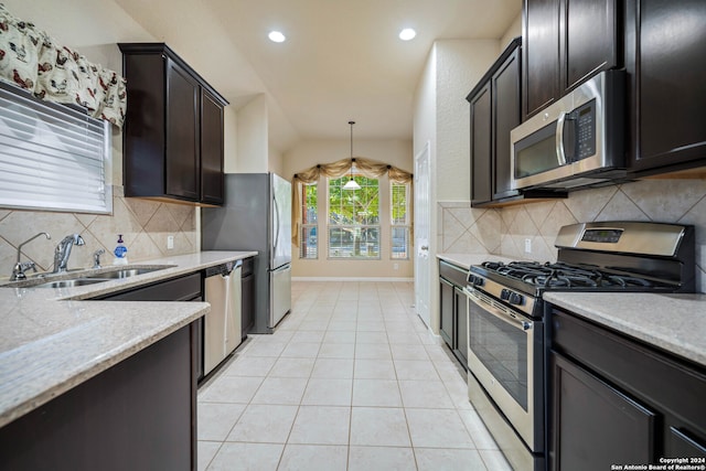 kitchen with sink, backsplash, hanging light fixtures, stainless steel appliances, and vaulted ceiling