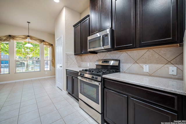 kitchen featuring decorative backsplash, stainless steel appliances, light tile patterned flooring, pendant lighting, and light stone counters