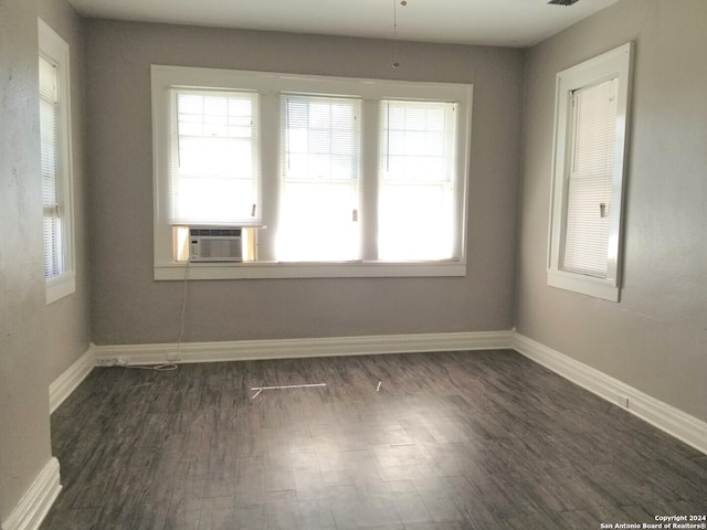 empty room featuring cooling unit and dark hardwood / wood-style flooring