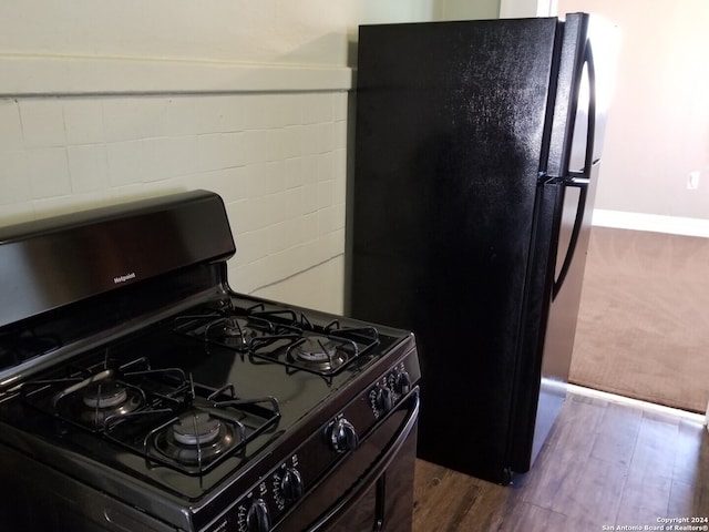 kitchen featuring black appliances and dark hardwood / wood-style flooring