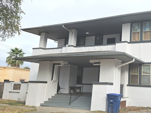 property entrance featuring a balcony and a porch