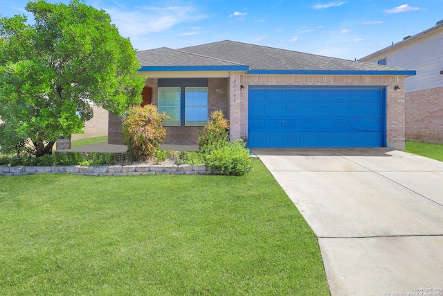 view of front of property featuring a garage, driveway, a front yard, and brick siding