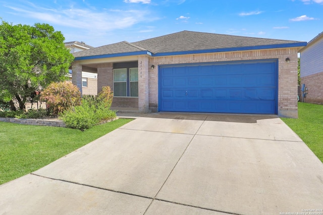 single story home featuring brick siding, concrete driveway, a front lawn, a garage, and roof with shingles
