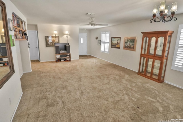 living room with carpet, a chandelier, ceiling fan, and baseboards