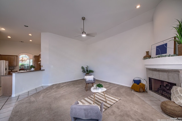 tiled living room with a fireplace and ceiling fan