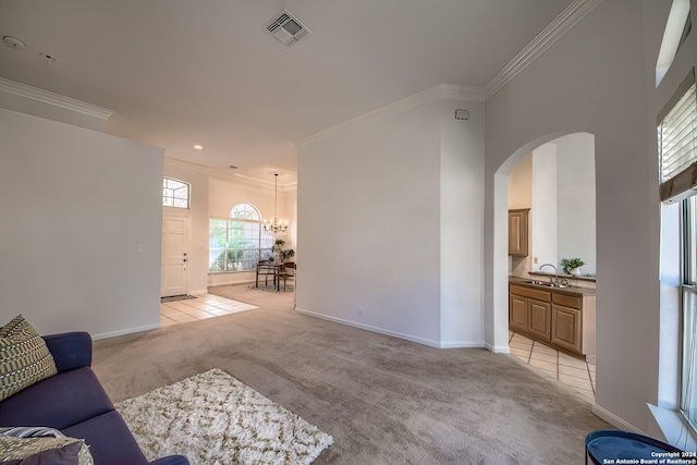 carpeted living room with ornamental molding, sink, and a chandelier