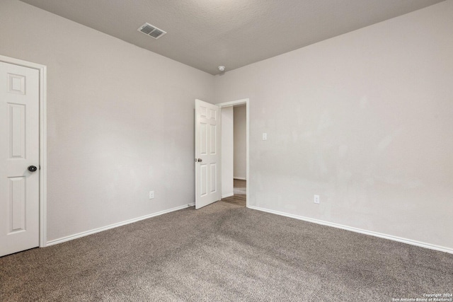 carpeted empty room featuring a textured ceiling