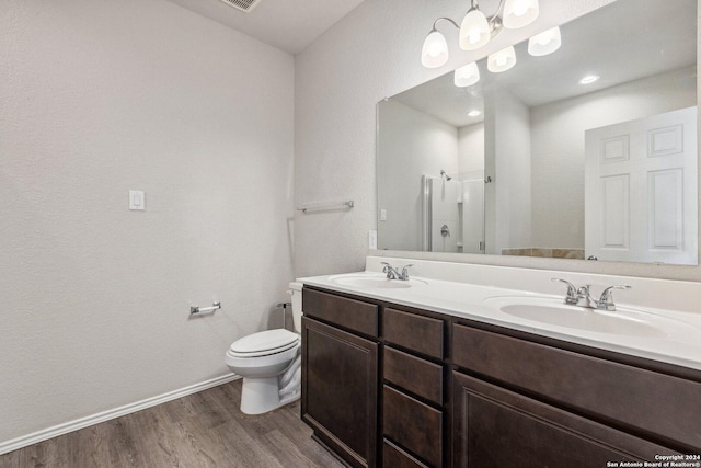 bathroom featuring walk in shower, toilet, vanity, and hardwood / wood-style flooring