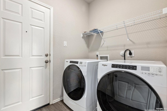 clothes washing area featuring washer and clothes dryer and dark hardwood / wood-style floors