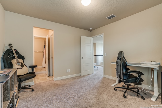 carpeted home office featuring a textured ceiling