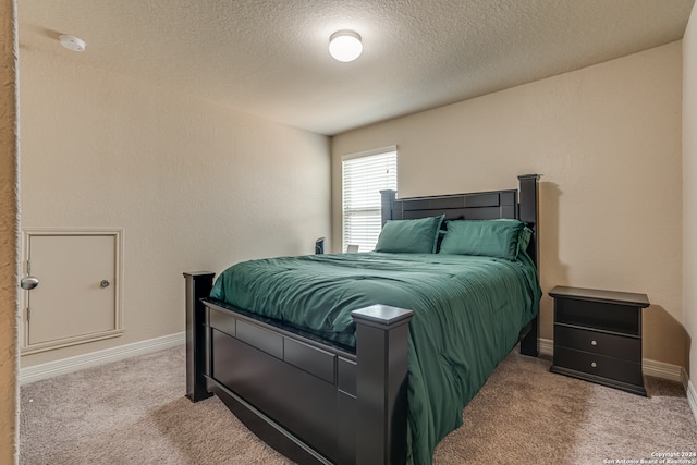 carpeted bedroom featuring a textured ceiling