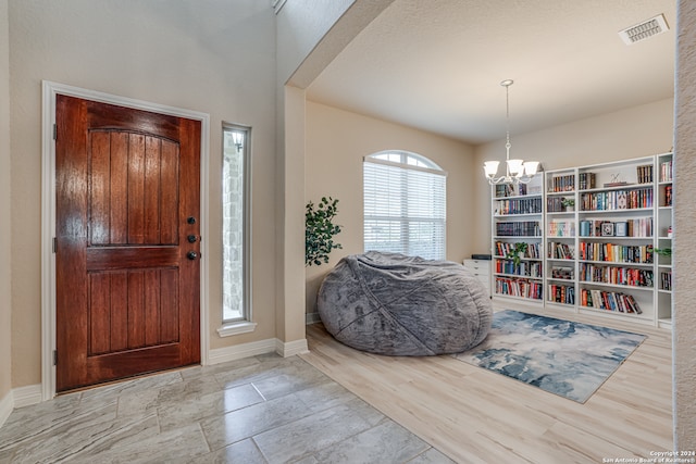 foyer featuring light hardwood / wood-style flooring and an inviting chandelier