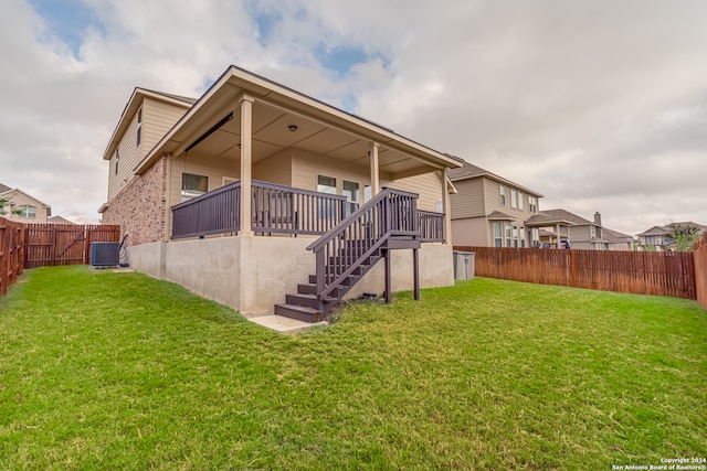 back of property featuring a yard and central AC