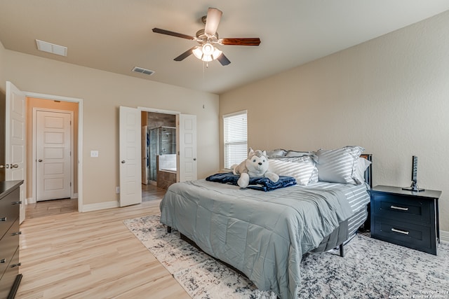 bedroom with light hardwood / wood-style flooring, ensuite bath, and ceiling fan