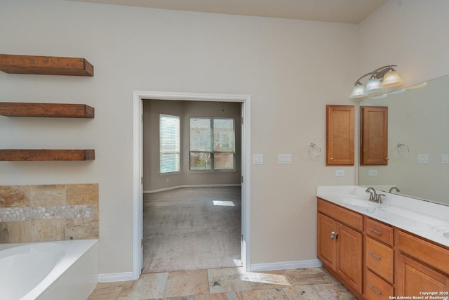 bathroom with baseboards, a garden tub, and vanity