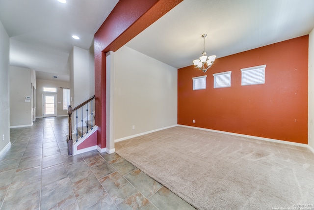 empty room with carpet floors and a chandelier