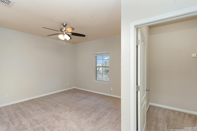 unfurnished bedroom featuring visible vents, baseboards, ceiling fan, and light carpet
