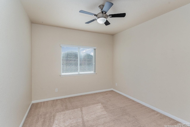 empty room with carpet flooring, a ceiling fan, and baseboards