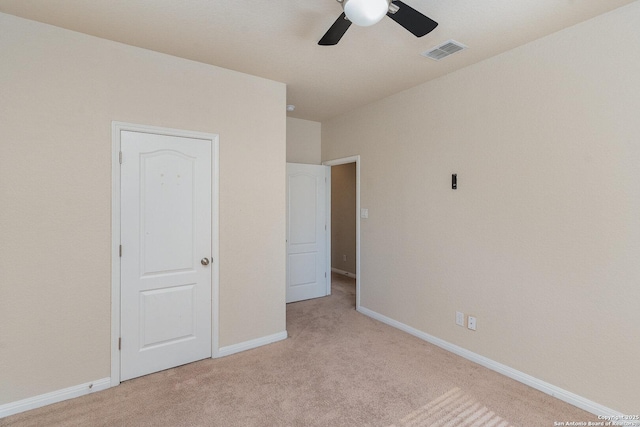 unfurnished bedroom featuring a ceiling fan, baseboards, visible vents, and light carpet