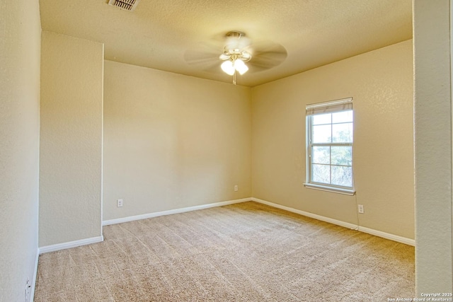 unfurnished room with visible vents, baseboards, ceiling fan, a textured ceiling, and carpet