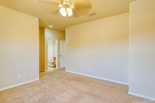 empty room with visible vents, baseboards, ceiling fan, and light colored carpet