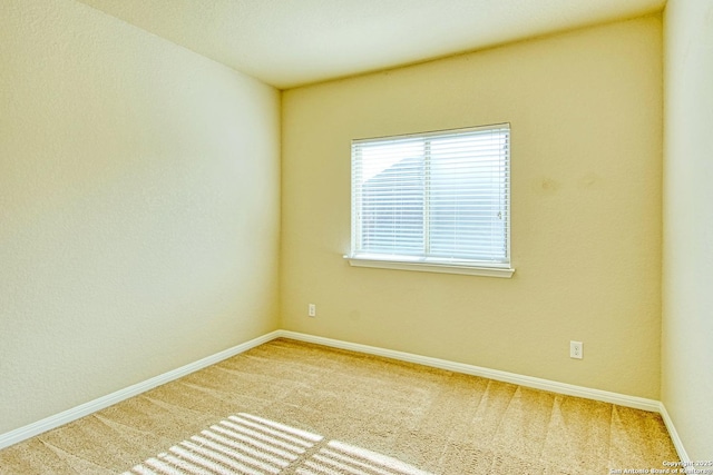 carpeted spare room featuring baseboards