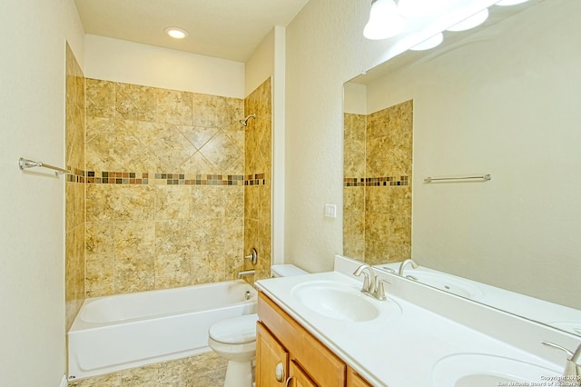 full bath featuring double vanity, a sink, bathtub / shower combination, and toilet