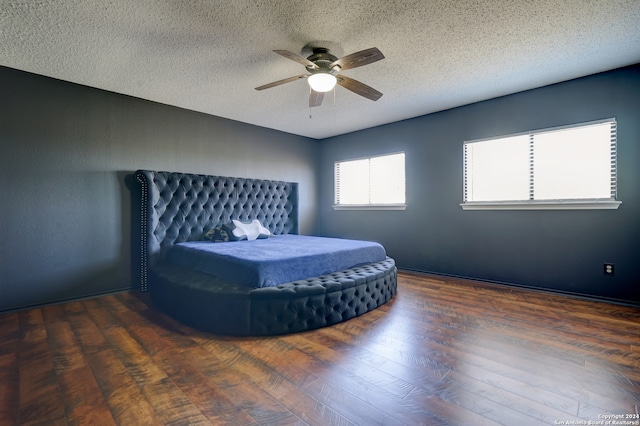 unfurnished bedroom with a textured ceiling, dark wood-type flooring, and ceiling fan