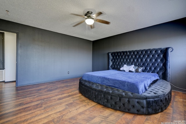 bedroom featuring a textured ceiling, dark hardwood / wood-style floors, and ceiling fan