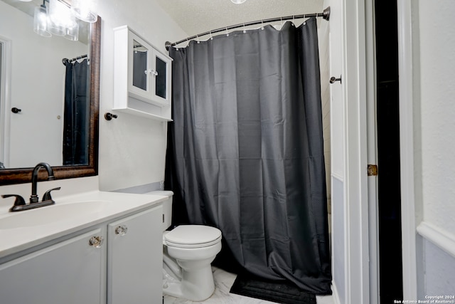 bathroom with vanity, a textured ceiling, toilet, and walk in shower