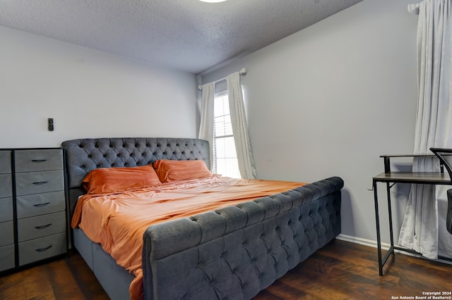 bedroom with a textured ceiling and dark hardwood / wood-style floors