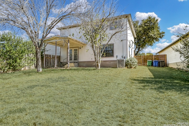 rear view of house featuring a yard and central AC