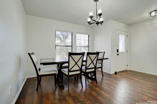 dining space featuring a notable chandelier, a textured ceiling, and dark hardwood / wood-style floors