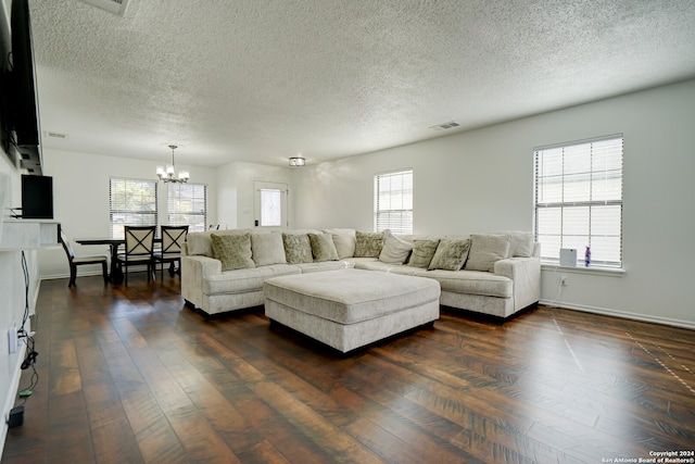 living room with a healthy amount of sunlight, a textured ceiling, and dark hardwood / wood-style flooring