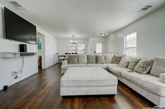 living room featuring a textured ceiling, a chandelier, and dark hardwood / wood-style flooring