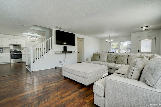 living room with an inviting chandelier, dark hardwood / wood-style floors, and a textured ceiling