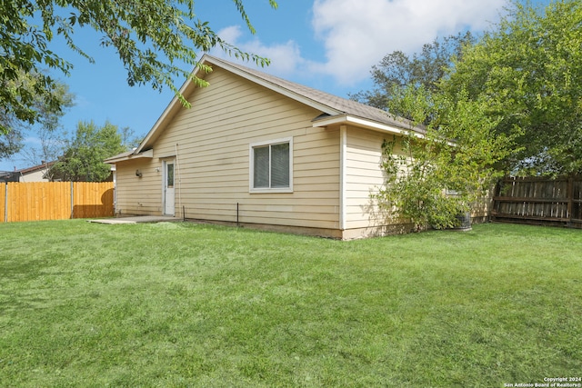 back of house with a patio and a lawn