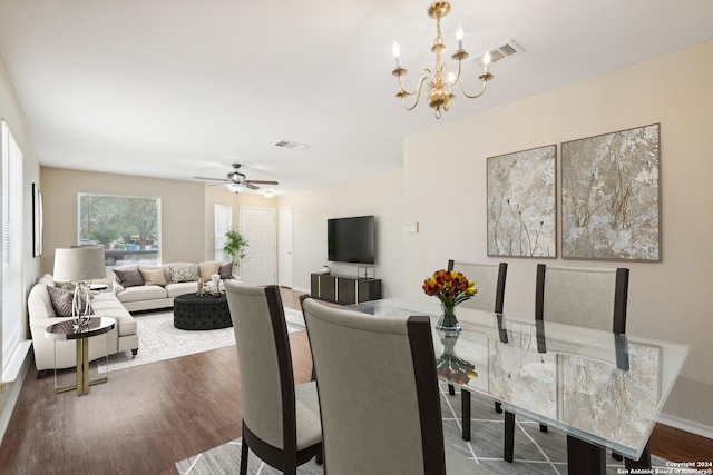 dining space with dark hardwood / wood-style floors and ceiling fan with notable chandelier