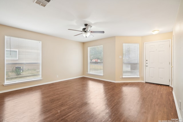 empty room featuring dark wood-type flooring and ceiling fan