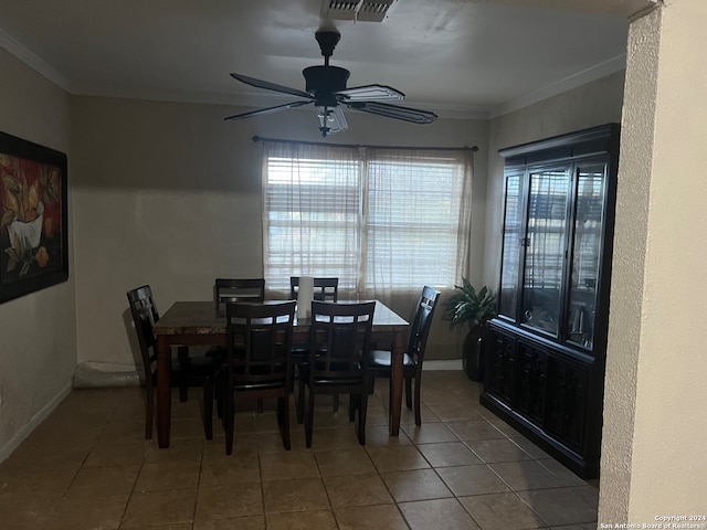 tiled dining area featuring ornamental molding and ceiling fan