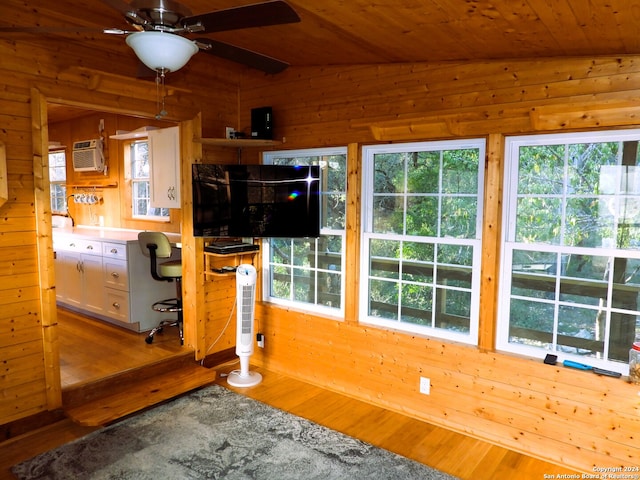 kitchen featuring white cabinetry, hardwood / wood-style flooring, vaulted ceiling, and wood walls