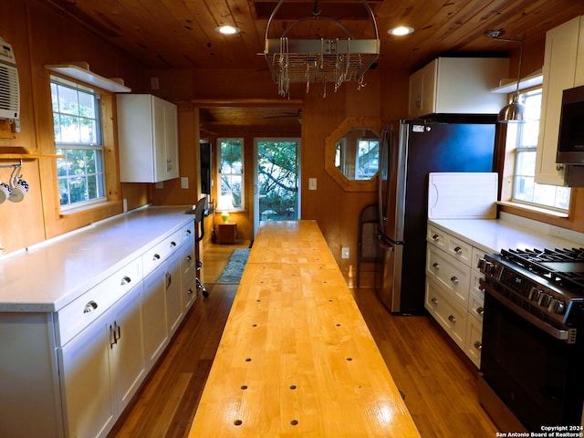 kitchen featuring wood ceiling, white cabinets, hardwood / wood-style floors, appliances with stainless steel finishes, and pendant lighting