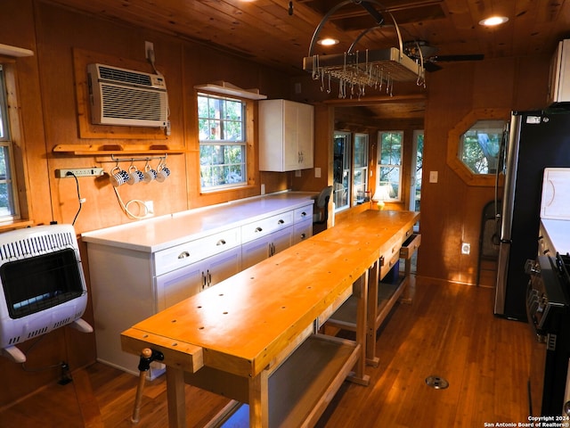 kitchen with white cabinets, wooden ceiling, wood-type flooring, and heating unit