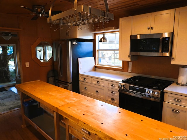 kitchen featuring wood counters, hanging light fixtures, stainless steel appliances, wooden ceiling, and dark wood-type flooring