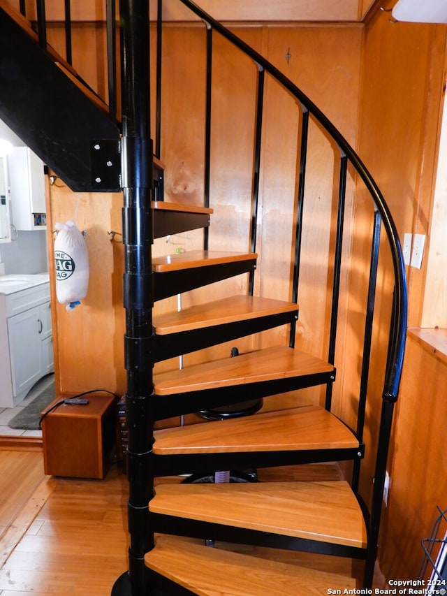 stairs featuring sink and hardwood / wood-style flooring