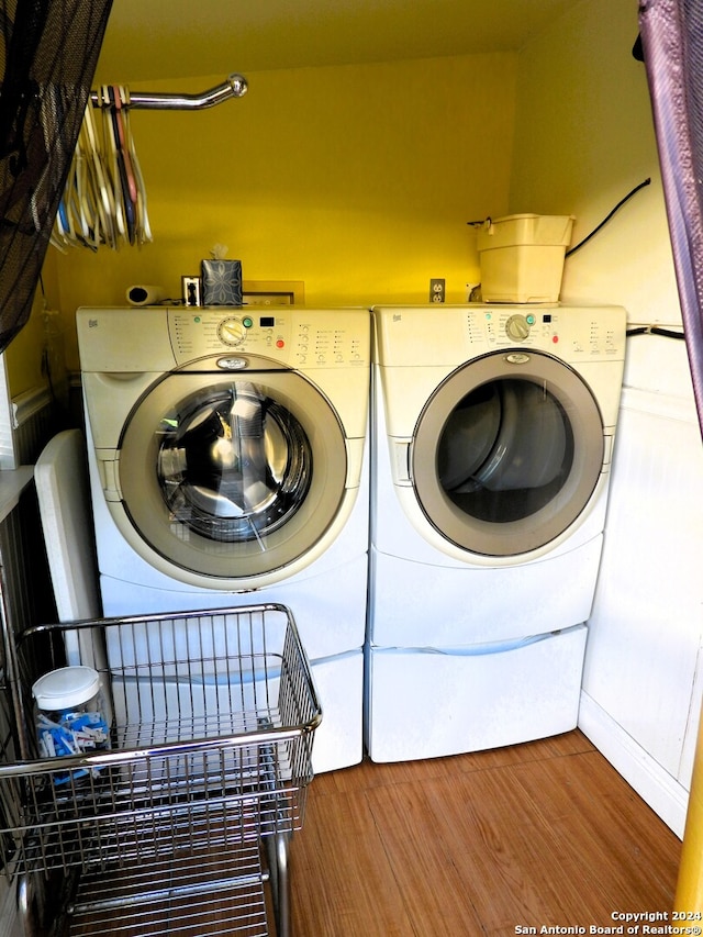 laundry area with hardwood / wood-style flooring and separate washer and dryer